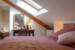 ein Schlafzimmer mit einem Bett und ein Badezimmer mit einem Dachfenster in der Unterkunft LES OLIVANIES 