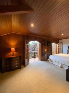 um quarto com uma cama e uma parede de madeira em Tília Pousada de Charme em Campos de Jordão