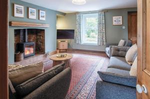 uma sala de estar com sofás e uma lareira em Hill House - 4 Bedroom Holiday Home - Llanrhidian em Llanrhidian