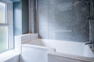 a bathroom with a tub and a glass shower at Hill House - 4 Bedroom Holiday Home - Llanrhidian in Llanrhidian +63 photos