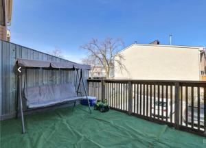 a porch swing with a canopy on a fence at Lush Abode! Close to ottawa airport.2 spacious bedrooms in Ottawa