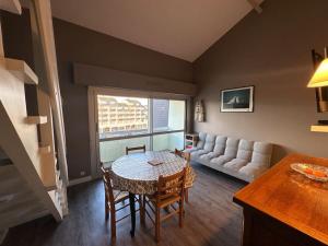 a living room with a table and a couch at Rêve de plage in Camiers +6 photos