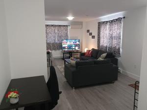 a living room with a couch and a tv at Bryana Suite - Comfy 1-Bedroom in Halifax