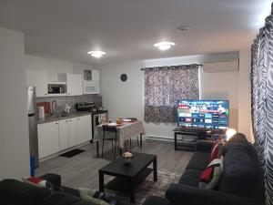 a living room with a couch and a kitchen at Bryana Suite - Comfy 1-Bedroom in Halifax