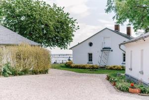 a driveway leading to a white building with a ladder at Inselresort Wilhelmstein in Steinhude