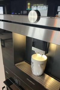 eine Kaffeemaschine mit einer Tasse auf der Mikrowelle in der Unterkunft Ladebua in Brunstad