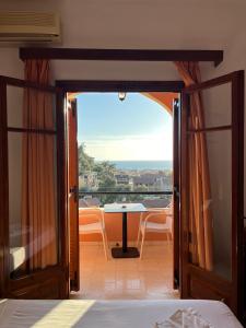 a room with a balcony with a table and a view at Aphrodite Apartments in Agios Gordios
