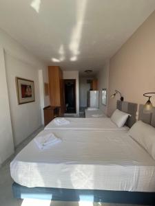 a bedroom with two large beds with white sheets at Aphrodite Apartments in Agios Gordios