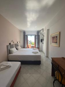 a large white bedroom with two beds and a window at Aphrodite Apartments in Agios Gordios