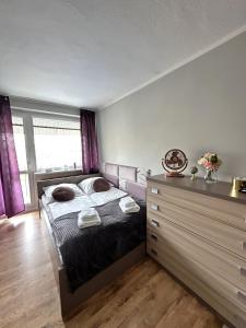 a bedroom with a bed with pillows and a dresser at Pokoje Gościnne in Kołobrzeg