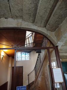 un couloir avec un escalier dans un bâtiment avec une porte dans l'établissement La Cadisserie en Gévaudan, à Marvejols