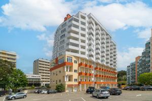 a rendering of a tall building with cars parked in a parking lot at Your Holidays Chrobry in Międzyzdroje