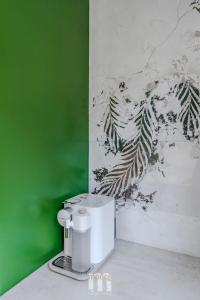 una pared verde y blanca con una cafetera en un mostrador en Tropical Jungle Apartament, en Otwock