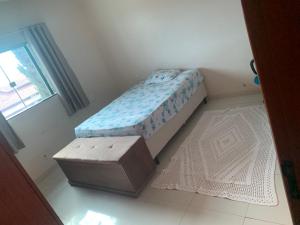 małe łóżko w pokoju z otomaną w obiekcie Casa w mieście Araxá