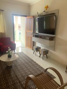 a living room with a flat screen tv on a wall at Casa in Araxá