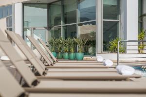 a group of chairs sitting next to a pool at Sesimbra Oceanfront Hotel - Preferred Hotels and Resorts in Sesimbra