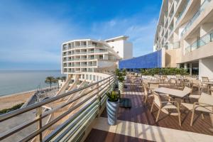 a balcony with tables and chairs and the ocean at Sesimbra Oceanfront Hotel - Preferred Hotels and Resorts in Sesimbra