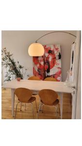 a dining room table with two chairs and a painting at Room in Marzili in Bern