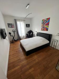 1 dormitorio con 1 cama y suelo de madera en Beau 3 pièces aux portes de PARIS, en Charenton-le-Pont