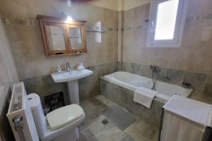 a bathroom with a sink and a toilet and a tub at Βίλα Χαρά in Eretria +19 photos
