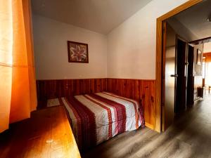 1 dormitorio con 1 cama con manta a rayas en Frontera Blanca, en Pas de la Casa