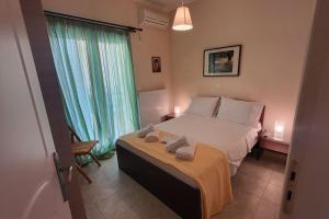 a bedroom with a large bed with two towels on it at Βίλα Χαρά in Eretria