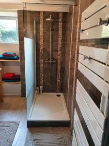 a shower with a glass door in a bathroom at Charmante maison en bord de Rance in Plouër-sur-Rance