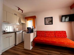 - une cuisine avec un canapé rouge dans une chambre dans l'établissement Frontera Blanca, au Pas de la Case