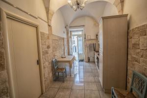a hallway with a dining room and a kitchen with a table at Casa Coppaiaia - Spaziosa e luminosa nel centro storico in Martina Franca