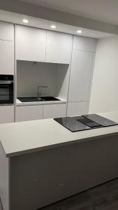 a kitchen with white cabinets and a sink at Reviv - Traumhaftes 3 Zimmer Apartment in Brühl