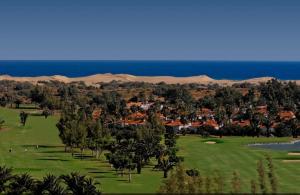 a golf course with palm trees and a resort at Espacioso Bungalow en Maspalomas in Maspalomas