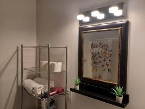 a bathroom with a mirror and a shelf with towels at Bryana Suite - Comfy 1-Bedroom in Halifax