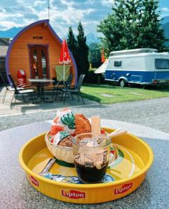 uma bandeja com uma cesta de comida e uma chávena de café em Camping Lazy Rancho - Eiger - Mönch - Jungfrau - Interlaken em Interlaken