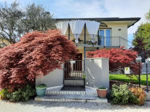 una casa con alberi rossi di fronte di Moreno House - Appartamento due camere a Castagnole