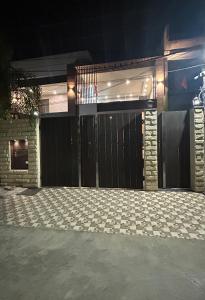 een huis met een zwarte poort en een oprit bij Wonderstays in Amritsar