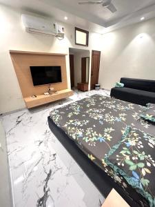 een slaapkamer met een groot bed en een flatscreen-tv bij Wonderstays in Amritsar