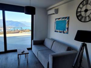 a living room with a couch and a clock on the wall at Bay View Village - Villa Eléanore 2 in Herceg-Novi
