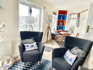 a living room with two chairs and a table at Cliff Cottage, Brixham in Brixham