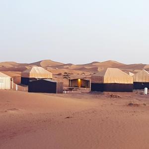 um grupo de edifícios no deserto em Nejma luxury camp erg chegaga em El Gouera
