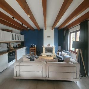 a living room with a white couch and blue walls at Traumhaftes Ferienhaus LENA direkt an der Ostsee in Łukęcin
