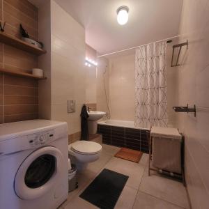 a bathroom with a washing machine and a toilet at Traumhaftes Ferienhaus LENA direkt an der Ostsee in Łukęcin