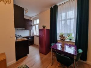 een keuken met een tafel en een rode koelkast bij Apartamenty Firfas 6 in Bydgoszcz