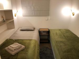 een kleine kamer met 2 bedden en een handdoek bij Aan 't Bos met sauna in Oudenaarde