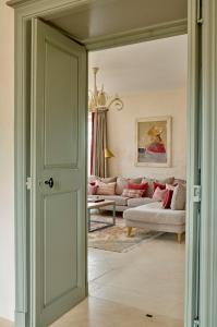 a door leading into a living room with a couch at Villa de La Roussie in Saint-Sulpice-de-Mareuil