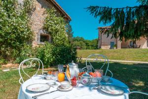 a table with a white table cloth and a tea pot at Villa de La Roussie in Saint-Sulpice-de-Mareuil