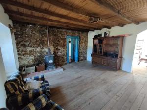 a living room with a couch and a stove at Private Farm - Kingdom of Stone - 1Km from River Beach in Tomar