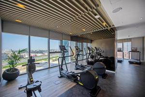 a gym with several treadmills and elliptical machines at Luxury One Bedroom Apartment In The Centre Of Dubai in Dubai