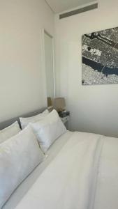 - un lit blanc avec des oreillers blancs dans une chambre dans l'établissement Luxury One Bedroom Apartment In The Centre Of Dubai, à Dubaï