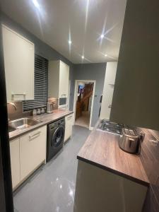 a kitchen with a sink and a washing machine at Impeccable 3-Bed House in York in York