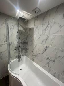 a white bath tub in a bathroom with marble walls at Impeccable 3-Bed House in York in York